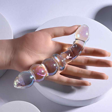 Female hand holding Glass Sex Toy double ended