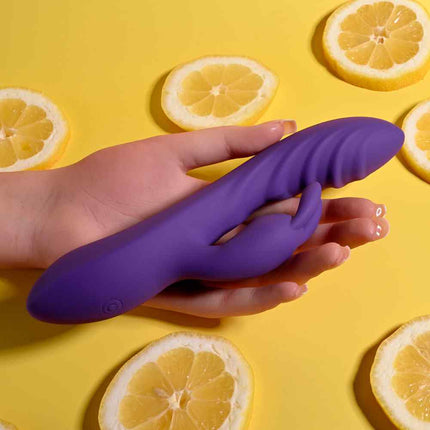 Female hand holding purple evolved Rabbit Vibrator