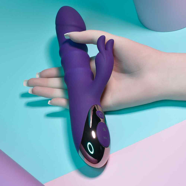 Female hand holding purple playboy rabbit sex toy