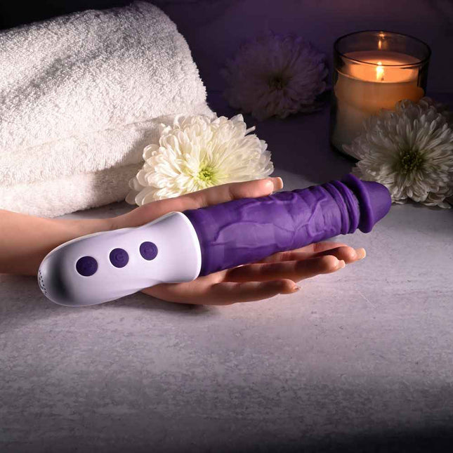 Hand Holding Purple Evolved PLUM THRUST Vibrating Dildo