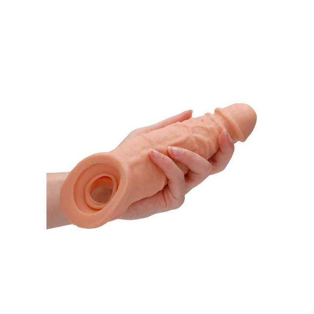 Male hand holding 9 inch realistic penis extender